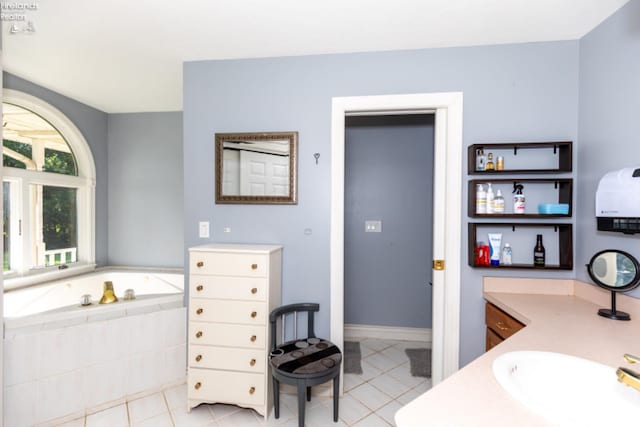 bathroom featuring vanity, a relaxing tiled tub, and tile patterned floors