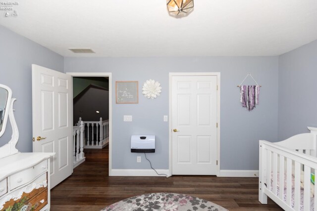 bedroom with dark wood-type flooring and a nursery area