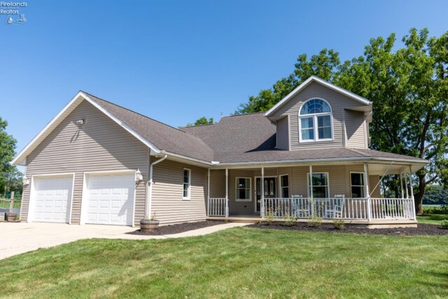 view of front of home with covered porch, a garage, and a front lawn