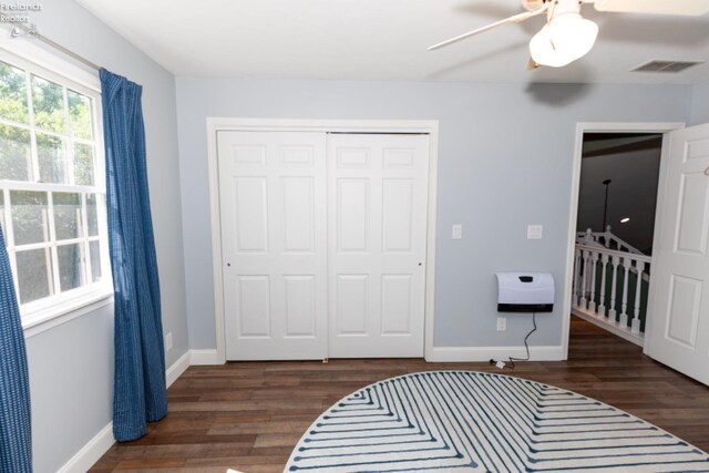 bedroom with ceiling fan, dark wood-type flooring, and a closet