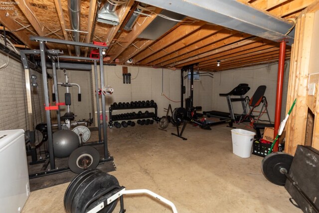 exercise room featuring washer / dryer and concrete floors