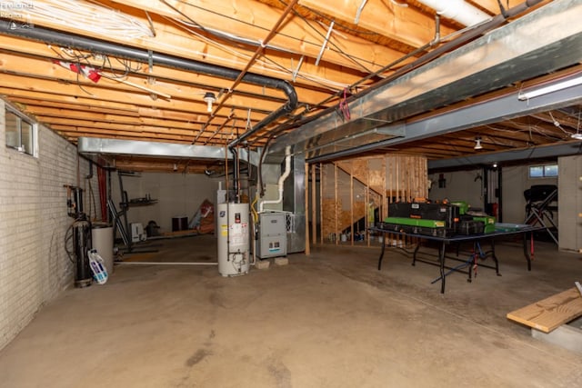 basement with heating unit, gas water heater, and brick wall