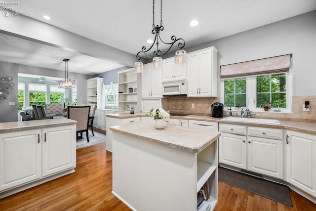 kitchen featuring a kitchen island, light wood-type flooring, and tasteful backsplash