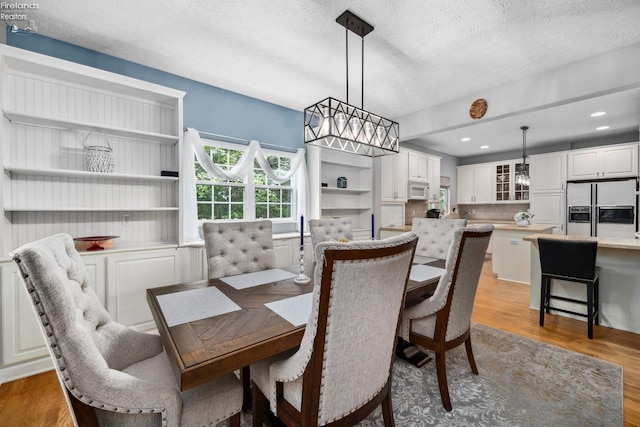 dining room featuring a textured ceiling and light hardwood / wood-style floors