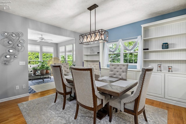 dining area with ceiling fan, a textured ceiling, and light hardwood / wood-style flooring