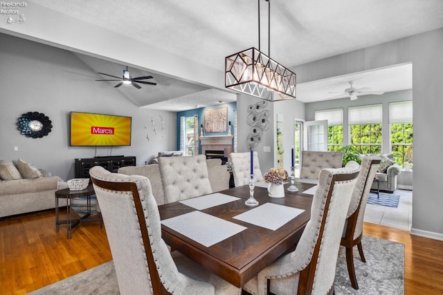 dining space featuring a textured ceiling, wood-type flooring, and ceiling fan