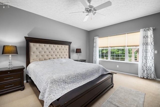 carpeted bedroom featuring a textured ceiling and ceiling fan