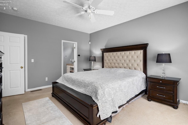 carpeted bedroom with a textured ceiling, ceiling fan, and connected bathroom