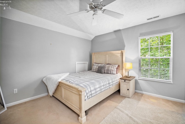 carpeted bedroom with ceiling fan and a textured ceiling