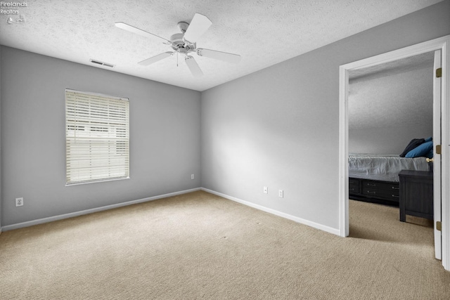 bedroom with light carpet, a textured ceiling, and ceiling fan