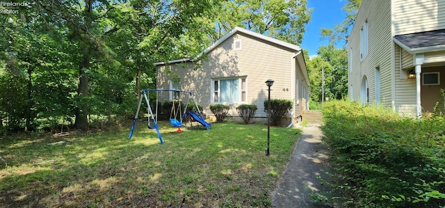 rear view of house with a playground and a lawn