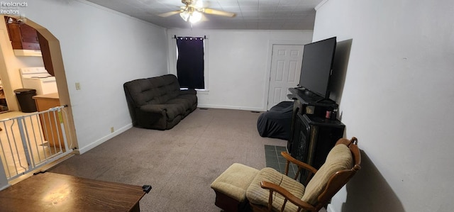 living area featuring ceiling fan, crown molding, carpet flooring, and washer / dryer