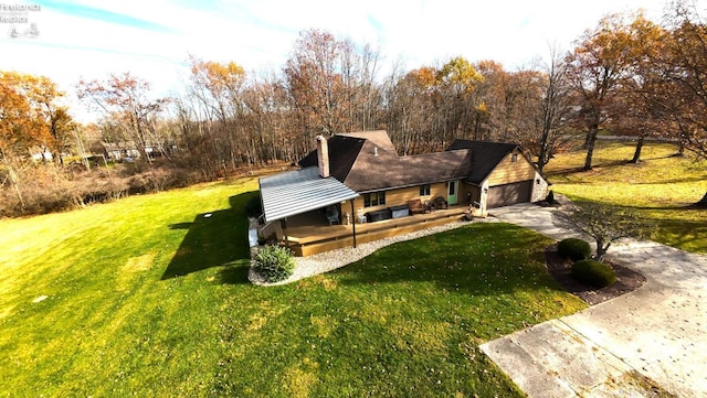 view of front facade featuring a garage, concrete driveway, a chimney, a porch, and a front yard