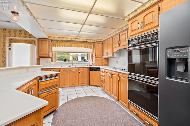 kitchen featuring black appliances, sink, and light tile patterned floors