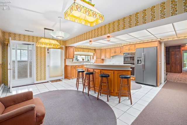 kitchen with plenty of natural light, appliances with stainless steel finishes, and light tile patterned flooring