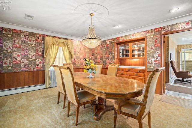 carpeted dining space with a notable chandelier and baseboard heating