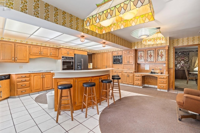 kitchen with light tile patterned flooring, a kitchen breakfast bar, and black appliances