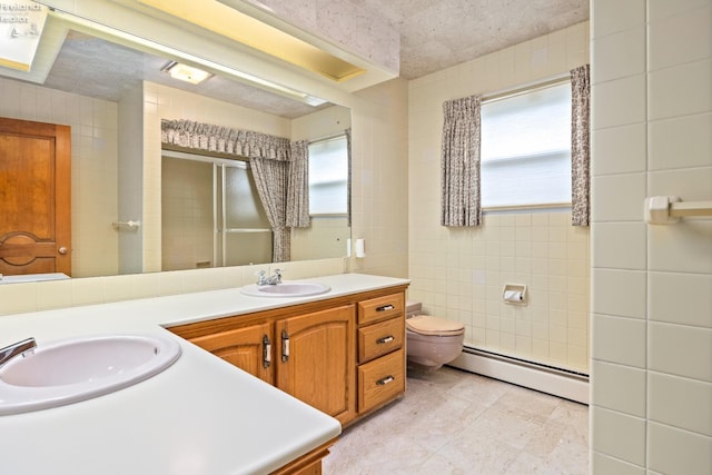 bathroom with tile walls, toilet, tile patterned floors, vanity, and baseboard heating