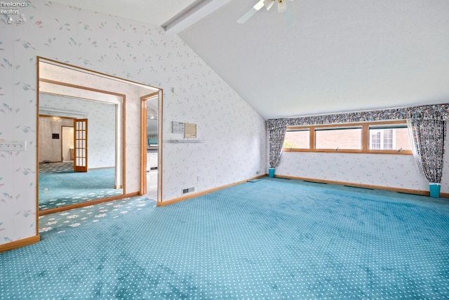 empty room with lofted ceiling with beams, carpet floors, and ceiling fan