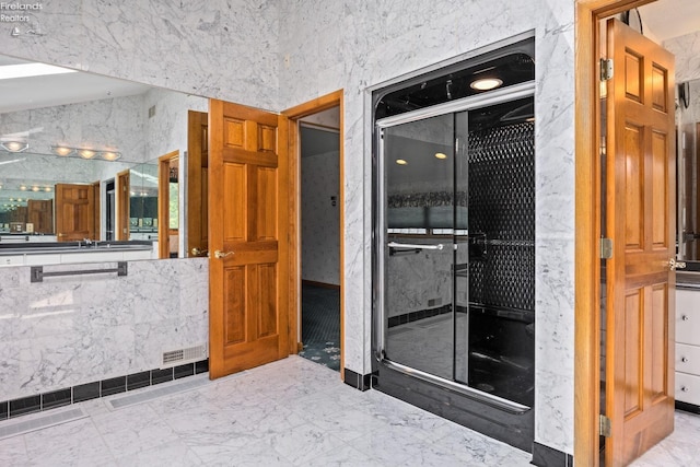 bathroom featuring tile patterned flooring and tile walls