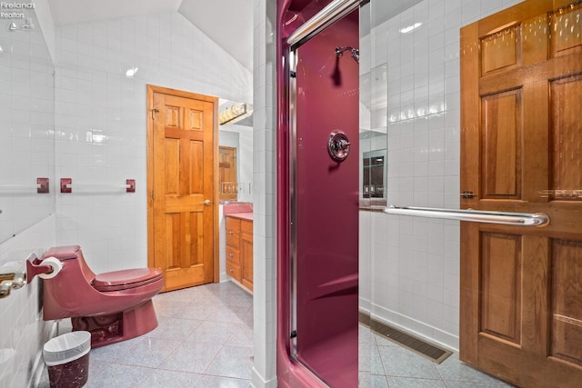 bathroom featuring vanity, tile patterned floors, tile walls, vaulted ceiling, and toilet