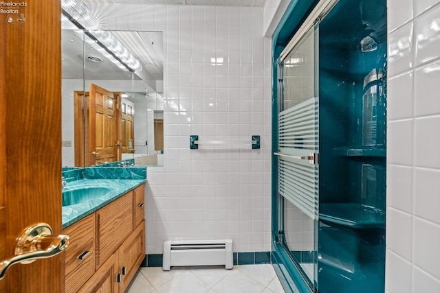 bathroom with vanity, tile patterned flooring, baseboard heating, and tile walls