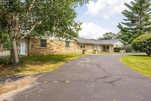 ranch-style house with a garage and a front lawn