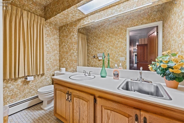 bathroom with a baseboard radiator, tile patterned floors, vanity, and toilet