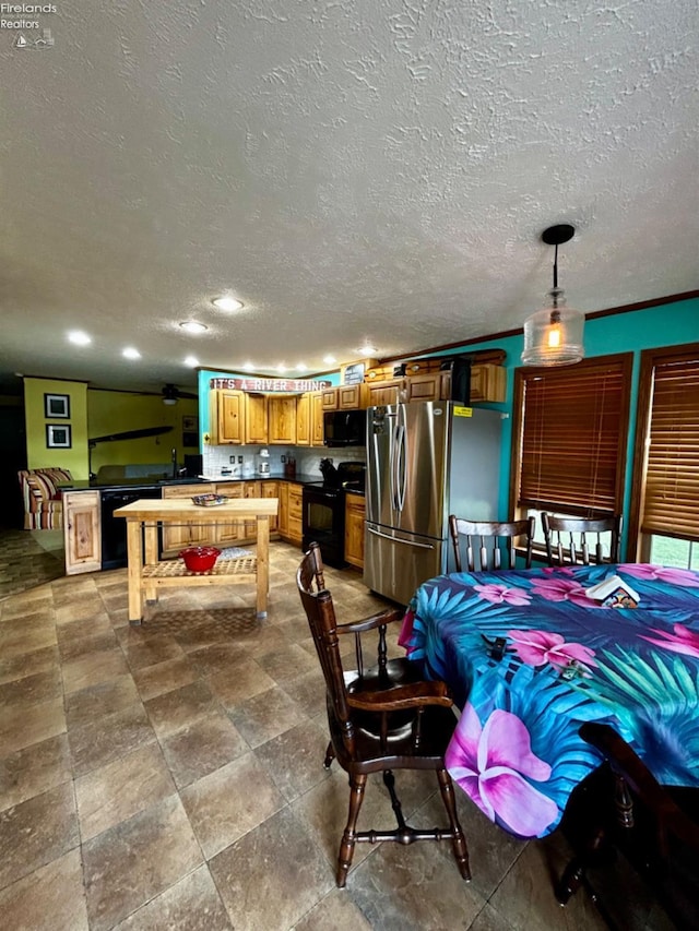 interior space with freestanding refrigerator, a textured ceiling, and recessed lighting