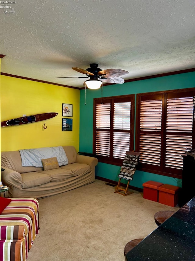 carpeted living area featuring a textured ceiling, baseboards, and a ceiling fan