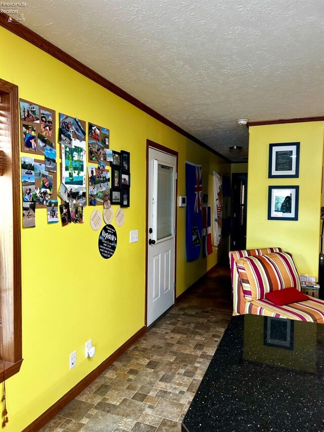 interior space featuring tile patterned floors, a textured ceiling, and ornamental molding