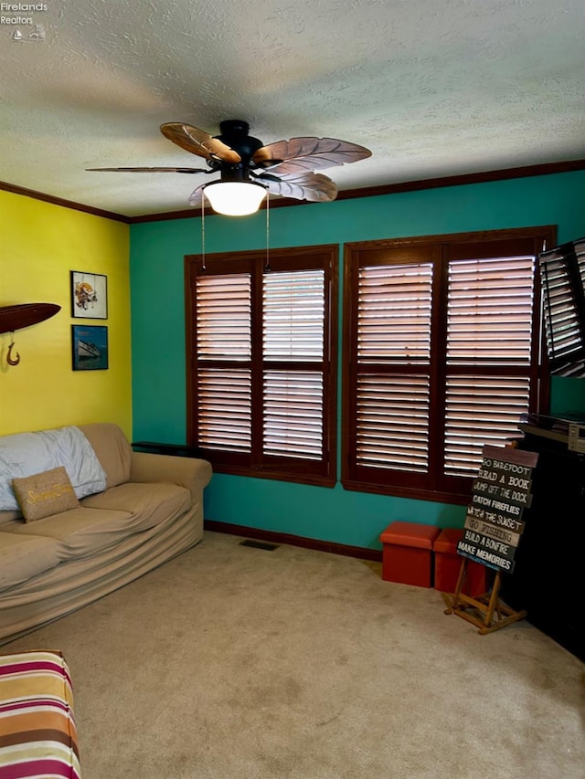 living room with visible vents, a ceiling fan, a textured ceiling, crown molding, and carpet floors