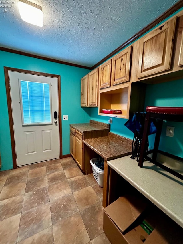 kitchen featuring ornamental molding and a textured ceiling