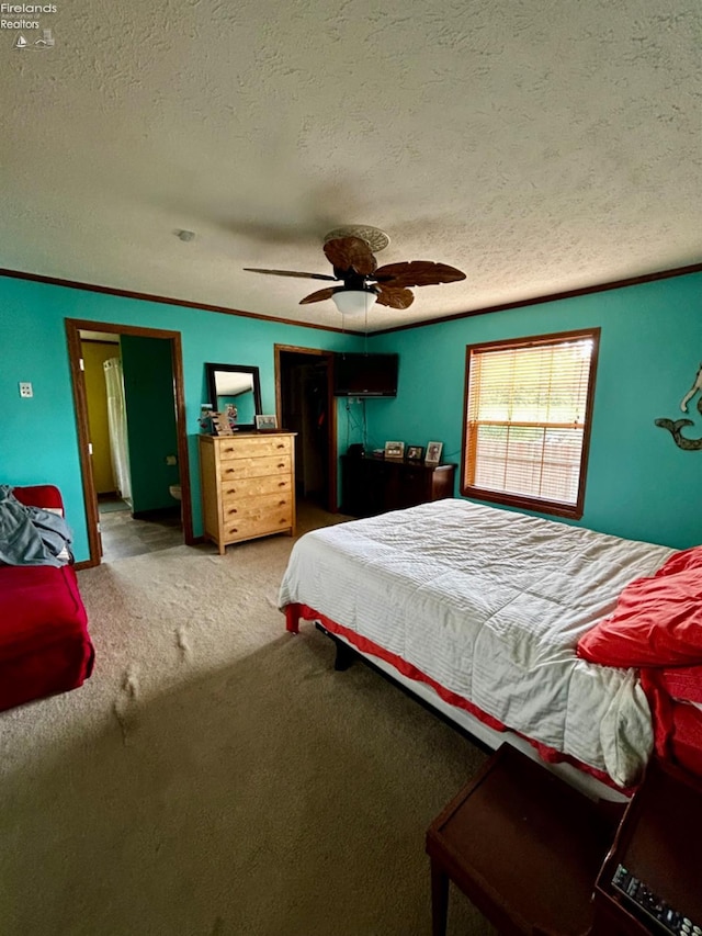 carpeted bedroom featuring ceiling fan and a textured ceiling