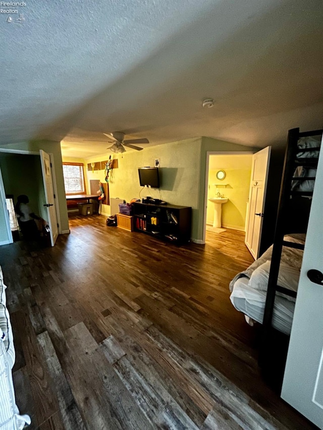 living area with a textured ceiling, a ceiling fan, and wood finished floors