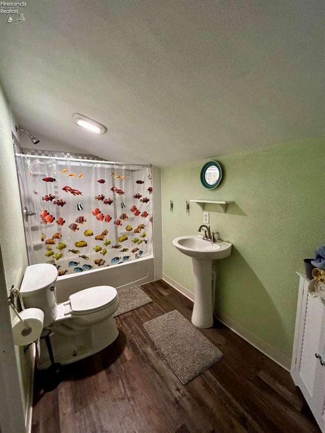 bathroom featuring radiator heating unit, hardwood / wood-style floors, shower / tub combo with curtain, a textured ceiling, and toilet