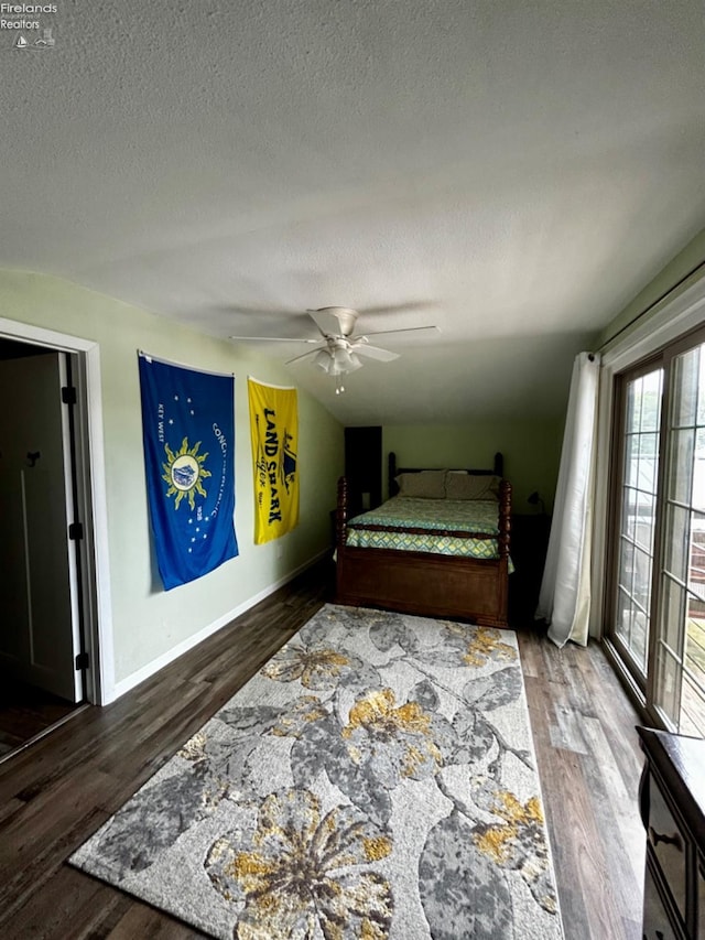 bedroom with a textured ceiling, wood finished floors, a ceiling fan, and baseboards