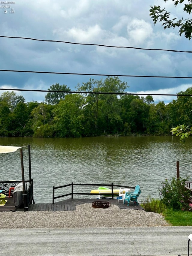 dock area featuring a water view and a view of trees