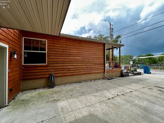 view of side of property featuring driveway and a patio area