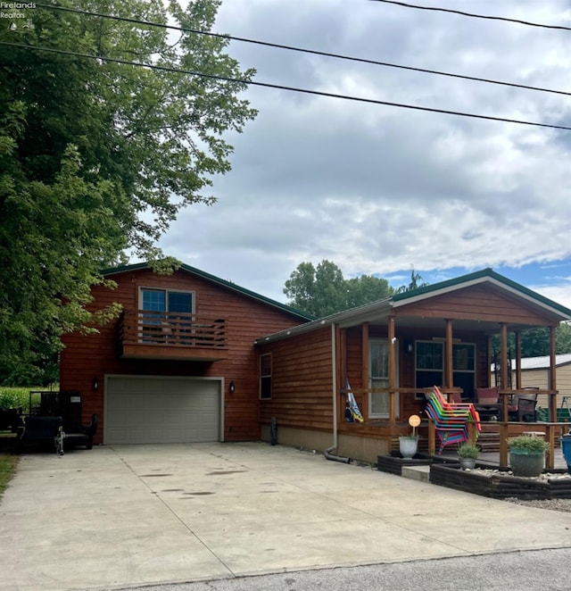 view of front of property featuring an attached garage, a porch, and concrete driveway