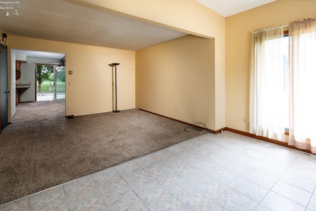 carpeted spare room with a textured ceiling