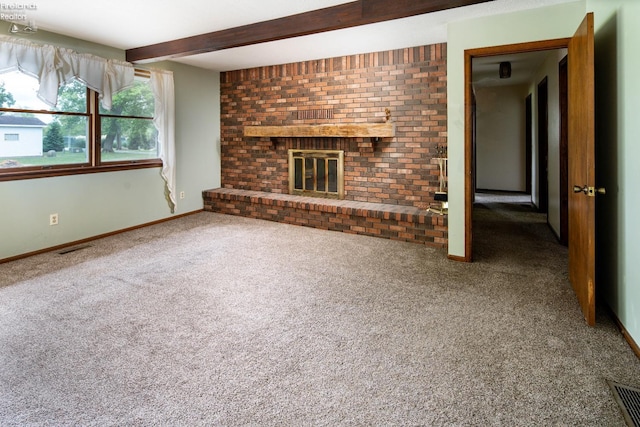 unfurnished living room with carpet floors, brick wall, a fireplace, and beamed ceiling