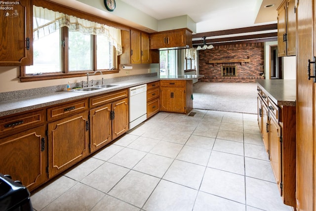 kitchen with white dishwasher, sink, a fireplace, light tile patterned floors, and brick wall