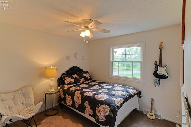 carpeted bedroom featuring a textured ceiling and ceiling fan