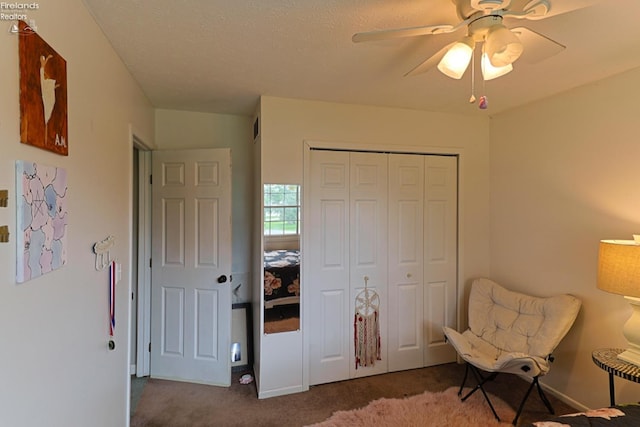 sitting room featuring carpet, a textured ceiling, and ceiling fan