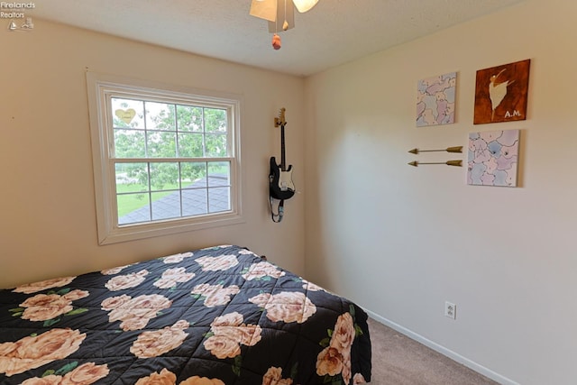 bedroom with carpet, a textured ceiling, and ceiling fan