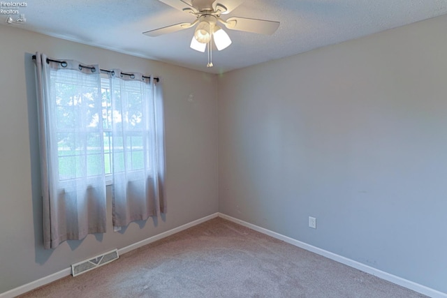 carpeted empty room featuring a textured ceiling and ceiling fan