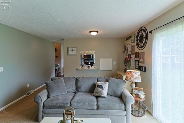 carpeted living room featuring a textured ceiling