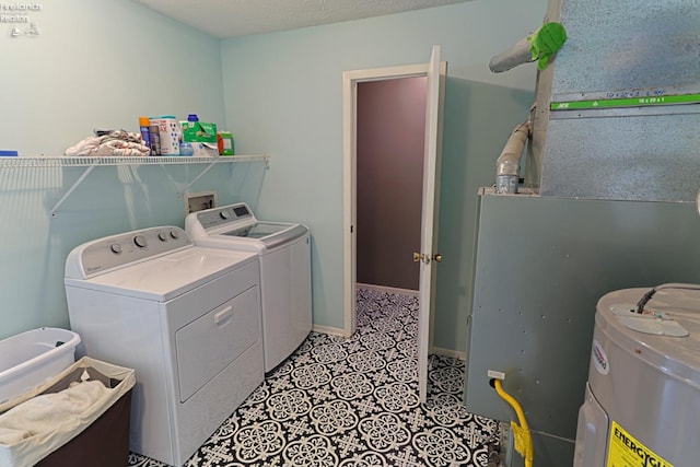 laundry area with light tile patterned flooring, a textured ceiling, water heater, and washer and dryer