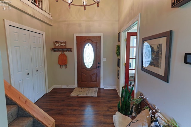 foyer with an inviting chandelier and dark hardwood / wood-style floors